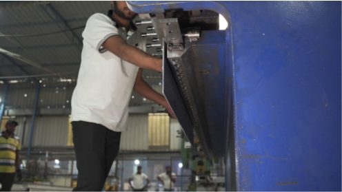 Worker operating punching machine for aluminium formwork manufacturing